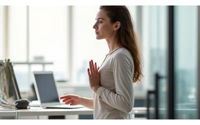 Femme faisant des étirements discrets à son bureau, souriante et détendue.